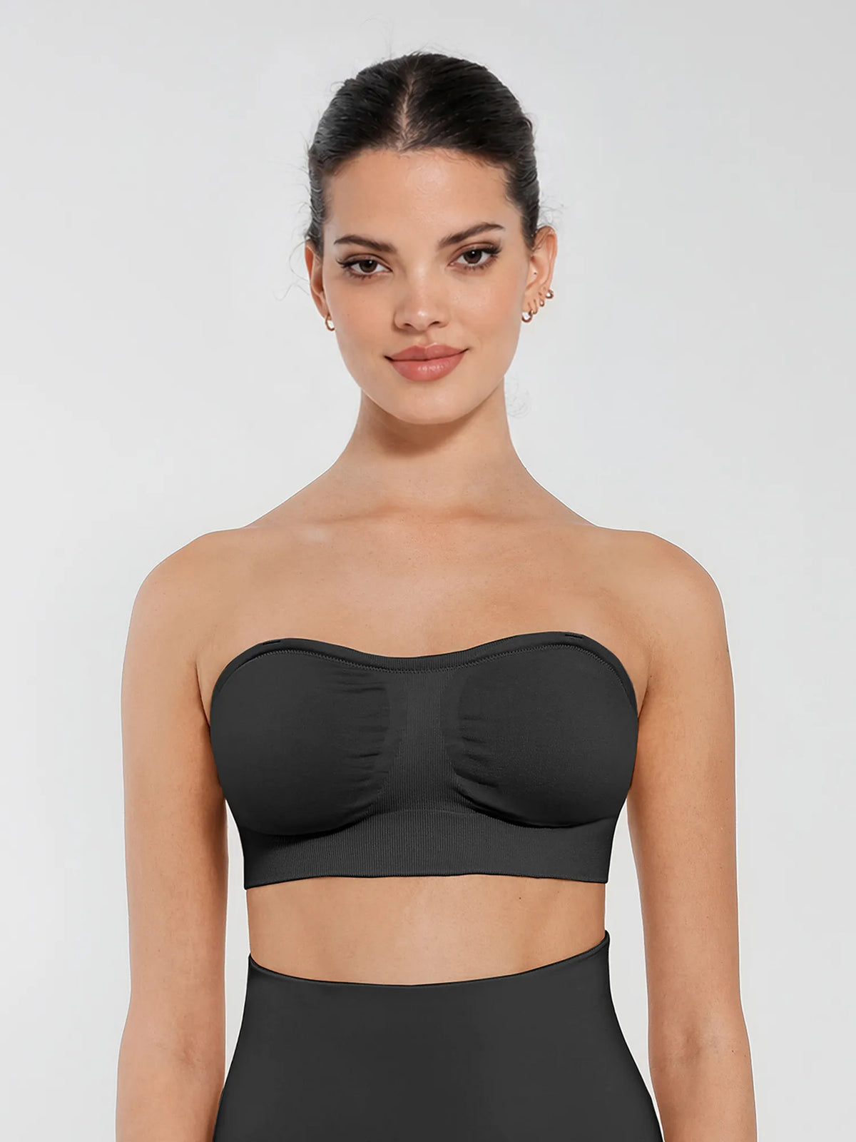 Front view of a model wearing a black seamless anti-slip bandeau bra featuring non-slip silicone grip and removable padding