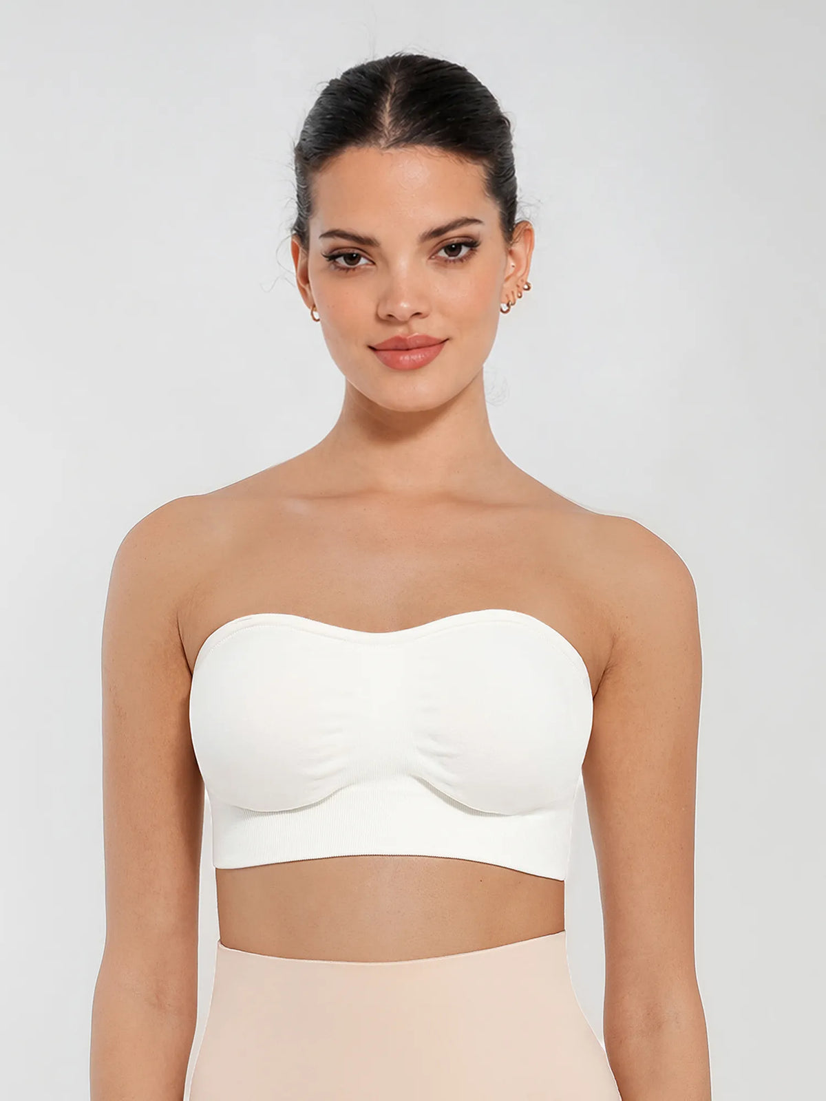 Front view of a model in a white seamless bandeau bra with gentle support and invisible second-skin comfort